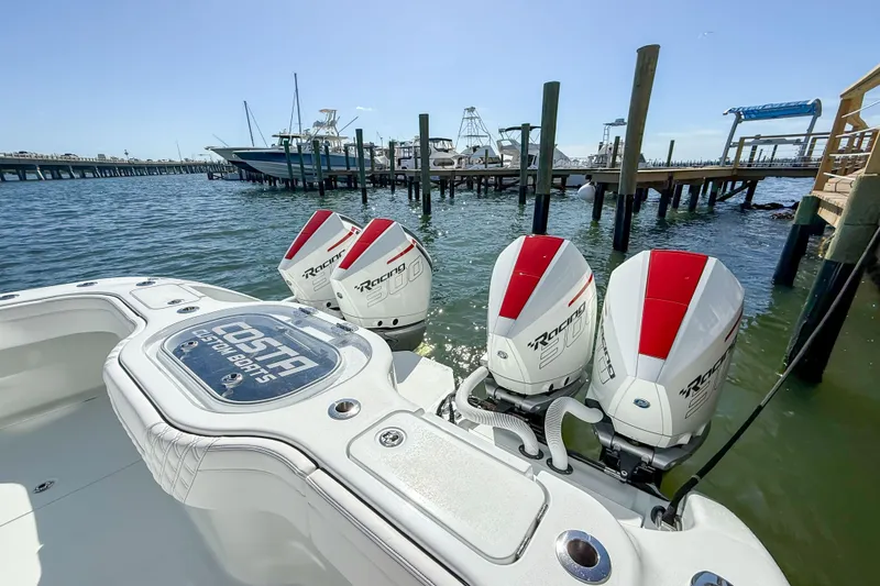Slide: The Image of 2023 Costa Custom Boats 34 with triple outboard engines docked at a marina. - 26