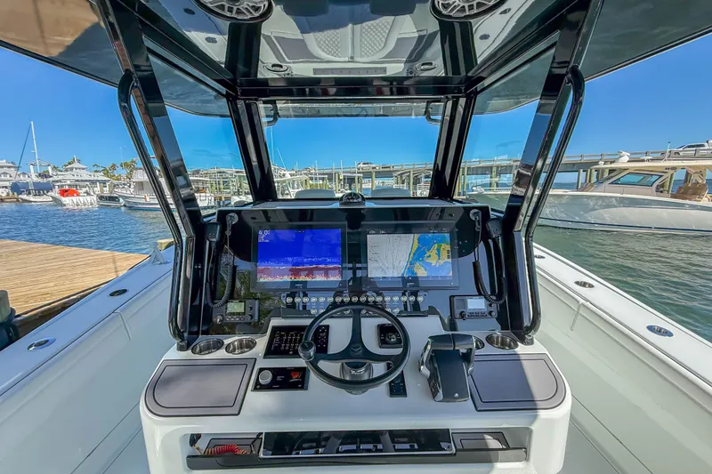 Slide: The Image of 2023 Costa Custom Boats 34 helm with advanced navigation system, docked at marina. - 5