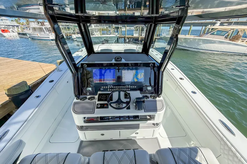 Slide: The Image of 2023 Costa Custom Boats 34 helm with advanced navigation system, docked at marina. - 6