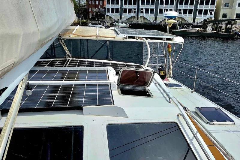 Slide: The Image of 1995 Catamaran St. Francis 43 with solar panels docked near waterfront buildings. - 11