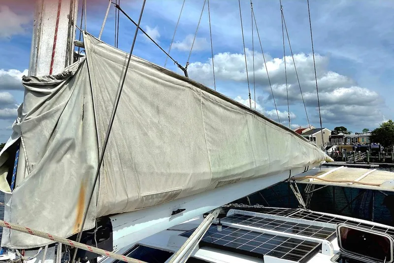 Slide: The Image of 1995 Catamaran St. Francis 43 with covered sail and solar panels, docked under blue sky. - 15