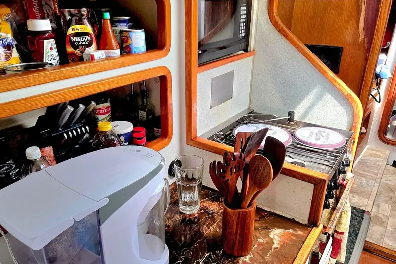 Slide: The Image of Compact kitchen area on a 1995 Catamaran St. Francis 43 with appliances and utensils. - 25