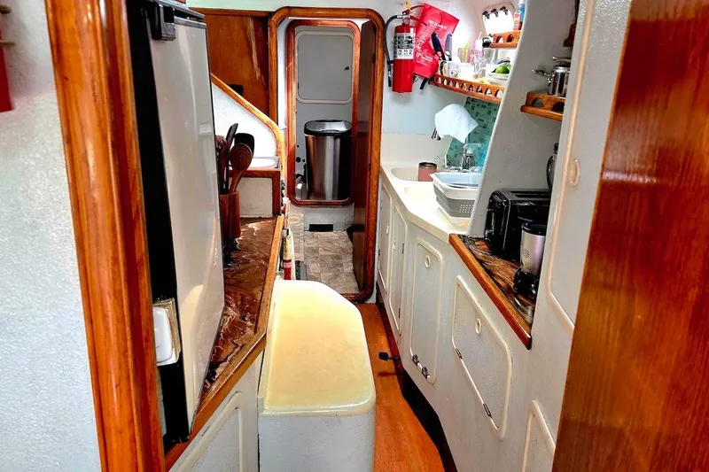 Slide: The Image of Interior of 1995 Catamaran St. Francis 43, featuring a compact kitchen area. - 29