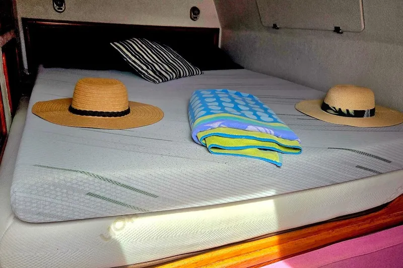 Slide: The Image of Cozy cabin interior of 1995 Catamaran St. Francis 43 with hats and towels on bed. - 34