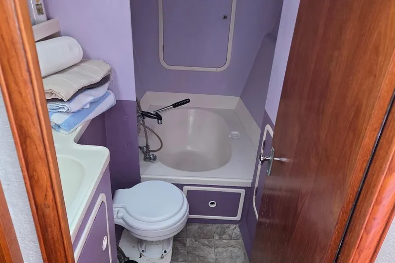 Slide: The Image of Bathroom interior of 1995 Catamaran St. Francis 43 with purple accents and compact design. - 35