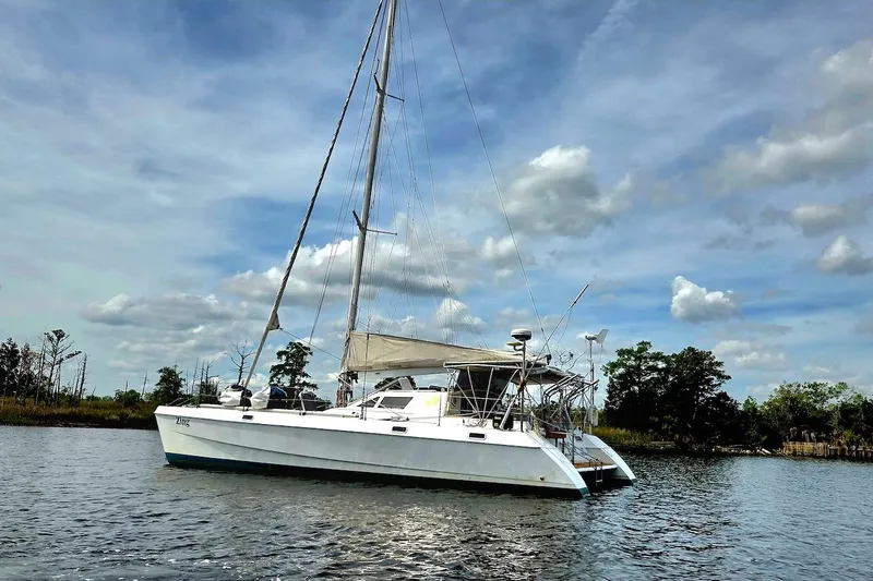 Slide: The Image of 1995 Catamaran St. Francis 43 sailing on calm waters under a partly cloudy sky. - 4