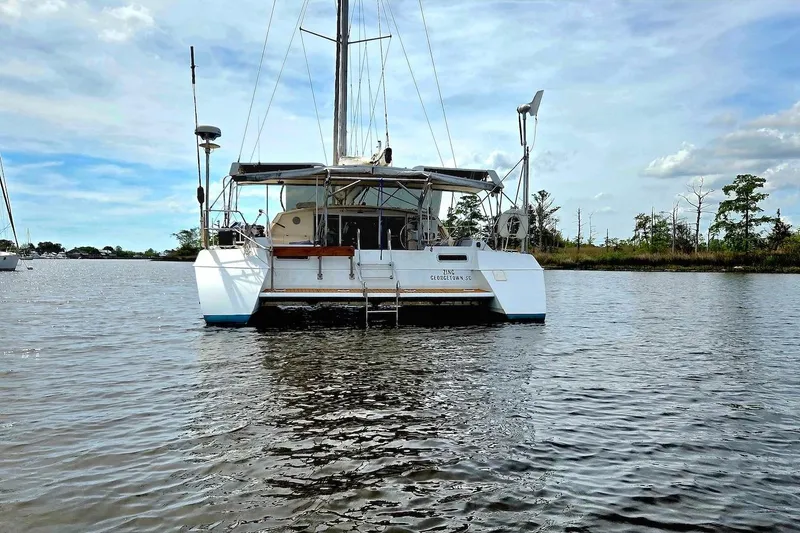 Slide: The Image of 1995 Catamaran St. Francis 43 on calm water, rear view, under a clear sky. - 6