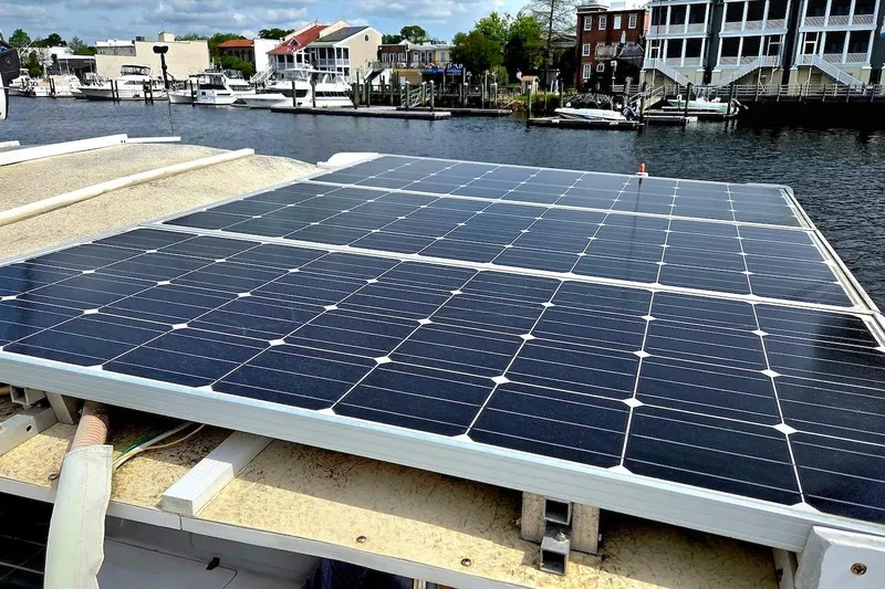Slide: The Image of Solar panels on a 1995 Catamaran St. Francis 43, docked near waterfront buildings. - 9