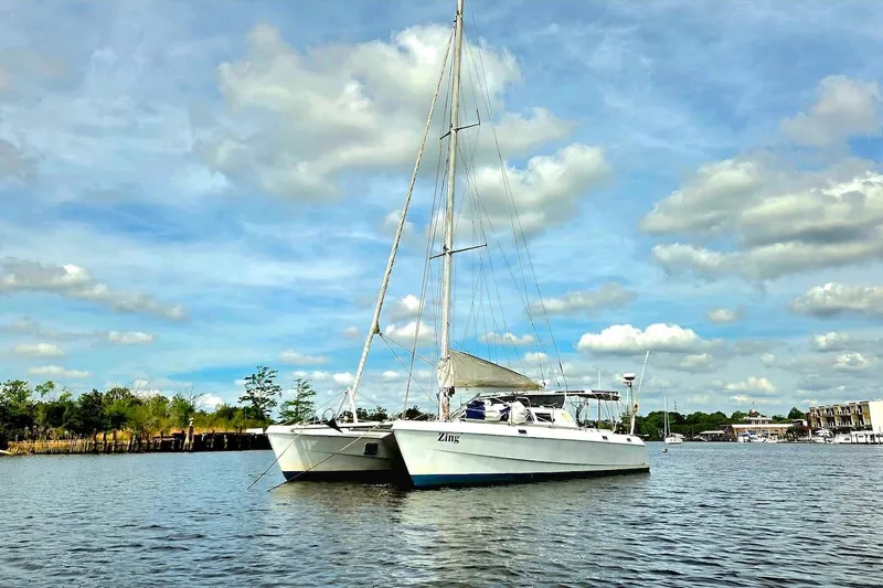 Slide: The Image of 1995 Catamaran St. Francis 43 sailing on a calm river under a blue sky. - 1