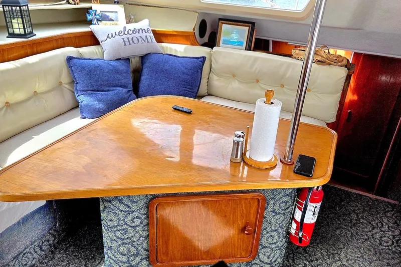 Slide: The Image of Cozy interior of 1995 Catamaran St. Francis 43 with cushions and wooden table. - 22