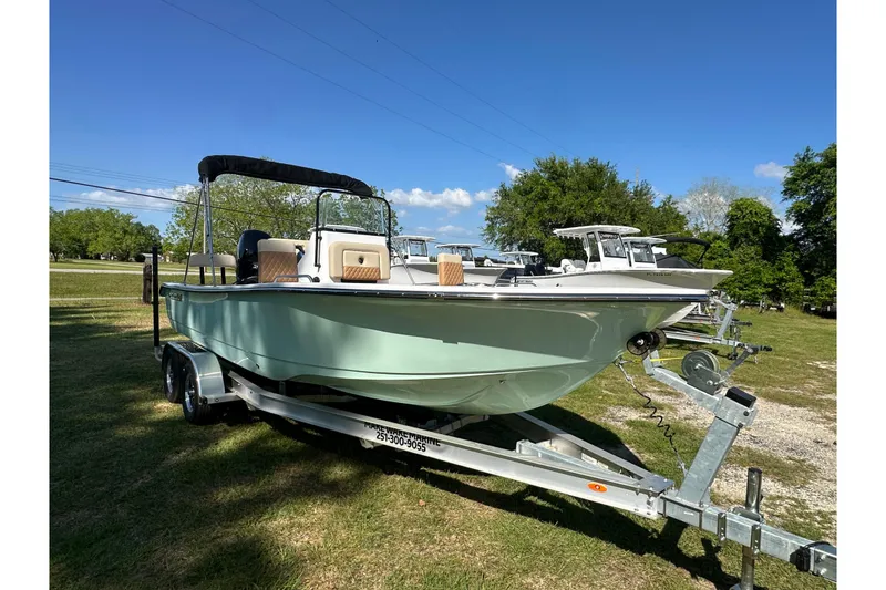 Slide: The Image of 2026 Action Craft 22 Bay boat on trailer, parked on grass under clear blue sky. - 10
