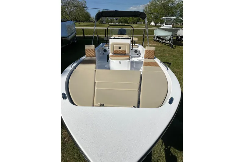 Slide: The Image of 2026 Action Craft 22 Bay boat with beige seating, displayed outdoors on grass. - 13