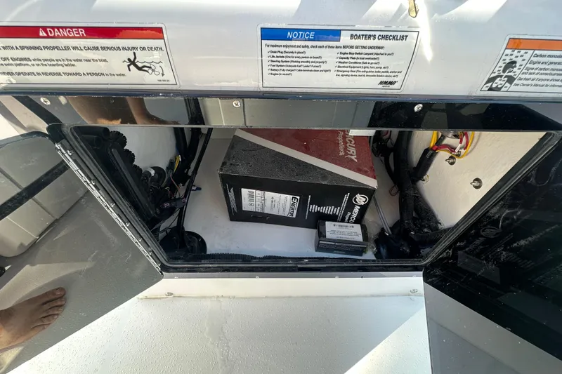 Slide: The Image of Open storage compartment in 2026 Action Craft 22 Bay boat, showing electrical components and wiring. - 24