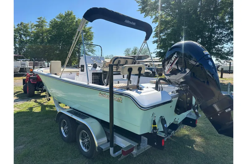 Slide: The Image of 2026 Action Craft 22 Bay boat on trailer with Mercury outboard motor, parked outdoors. - 3