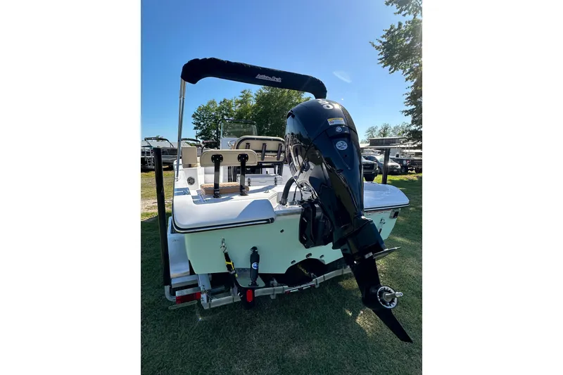 Slide: The Image of 2026 Action Craft 22 Bay boat with outboard motor, parked on grass under clear sky. - 4