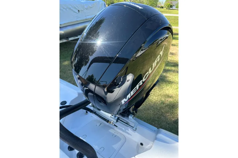 Slide: The Image of 2026 Action Craft 22 Bay boat with Mercury outboard engine, parked on grass. - 42