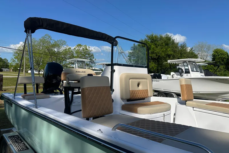 Slide: The Image of 2026 Action Craft 22 Bay boat with cushioned seating and canopy, parked outdoors. - 46