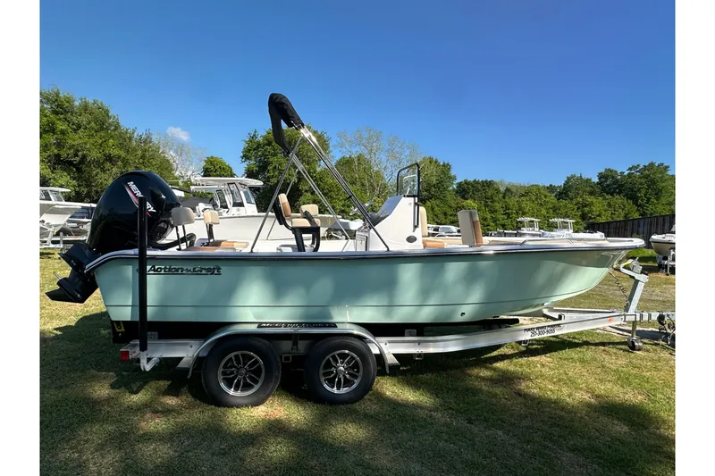 Slide: The Image of 2026 Action Craft 22 Bay boat on trailer, parked on grass under clear blue sky. - 8