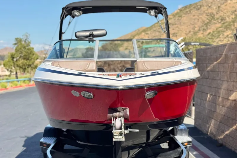 Slide: The Image of 2010 Regal 2300 RX Bowrider boat on trailer, red hull, parked outdoors. - 2