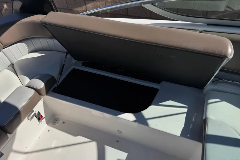 Slide: The Image of 2010 Regal 2300 RX Bowrider interior storage compartment with open lid and cushioned seating. - 27