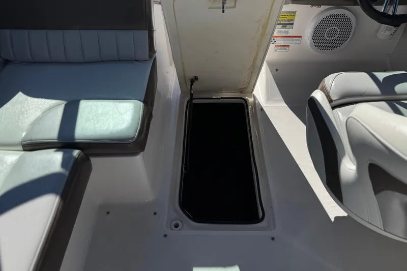 Slide: The Image of 2010 Regal 2300 RX Bowrider interior with open storage compartment and seating. - 28