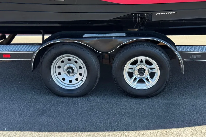 Slide: The Image of Trailer wheels of a 2010 Regal 2300 RX Bowrider boat on pavement. - 35