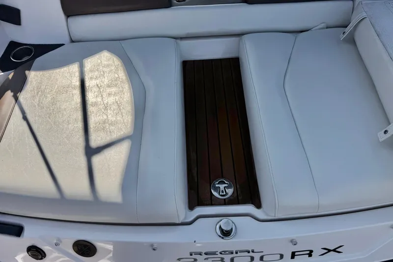Slide: The Image of 2010 Regal 2300 RX Bowrider boat interior with white seating and wood accents. - 9