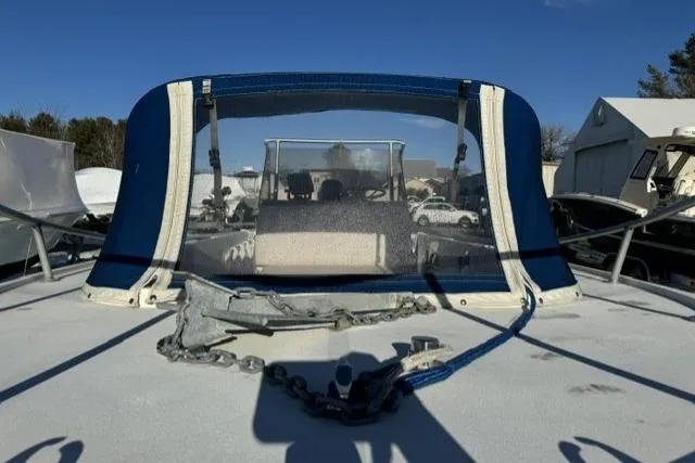 Slide: The Image of 1991 Mako 191 Inshore boat with anchor and blue canopy in a marina setting. - 10