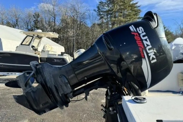 Slide: The Image of Suzuki outboard motor on a 1991 Mako 191 Inshore boat, parked outdoors. - 11