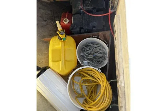 Slide: The Image of Storage compartment with yellow fuel container, ropes, and cables on a 1976 CAL 3-30 boat. - 14