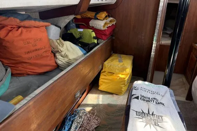 Slide: The Image of Interior of a 1976 CAL 3-30 sailboat with storage bags and folded linens. - 4