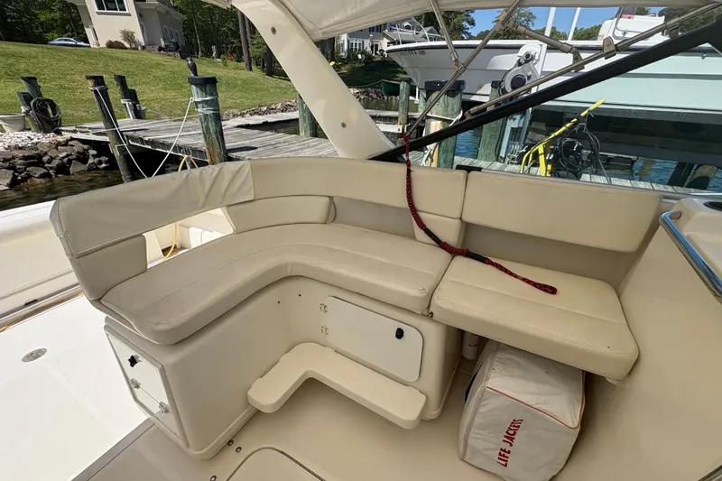 Slide: The Image of 1994 Tiara Yachts 3100 Open cockpit with helm, docked by a serene lake. - 13