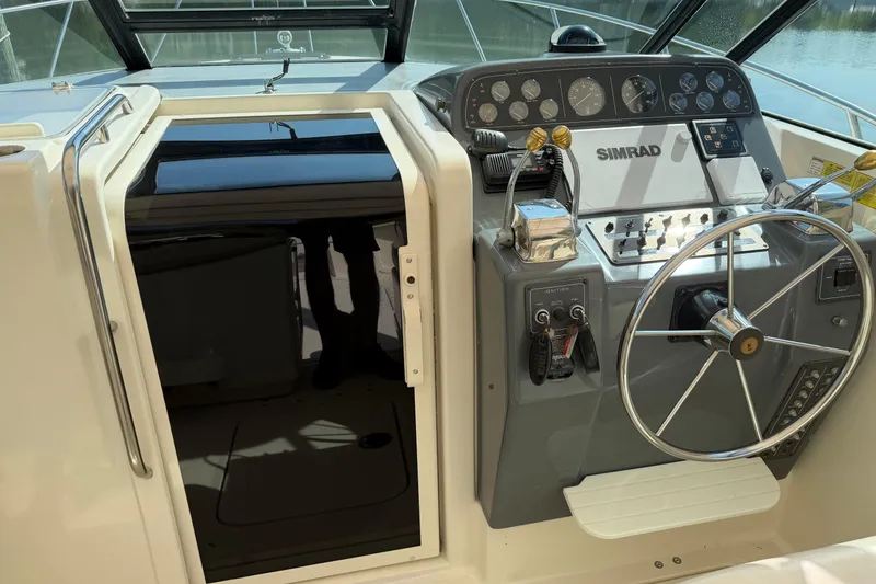 Slide: The Image of 1994 Tiara Yachts 3100 Open helm with steering wheel and control panel. - 2