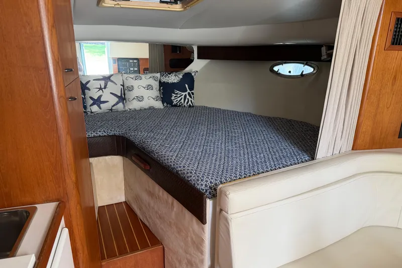 Slide: The Image of Interior of 1994 Tiara Yachts 3100 Open with wood table and cream seating. - 3