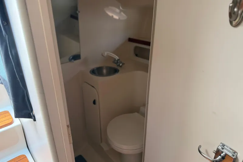 Slide: The Image of 1994 Tiara Yachts 3100 Open cockpit with helm, seating, and scenic water view. - 6