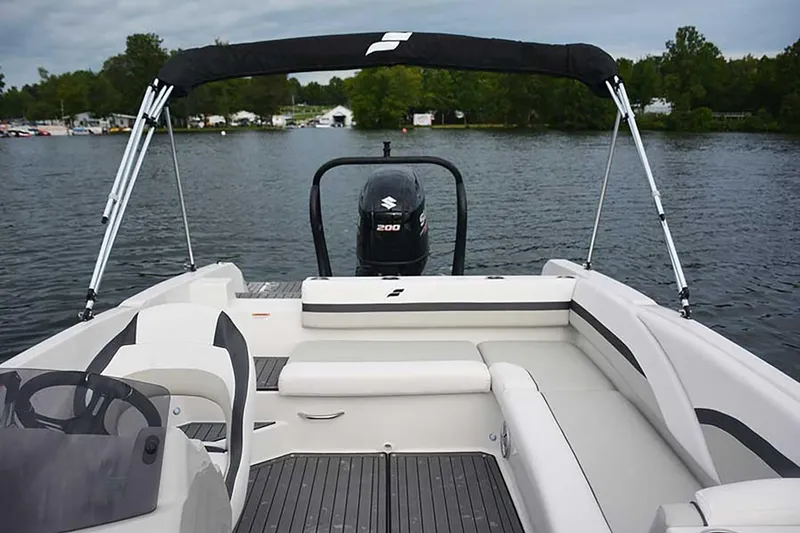 Slide: The Image of Manufacturer Provided Image: 2026 Starcraft SVX 211 OB boat with seating, outboard motor, and canopy on a lake. - 11
