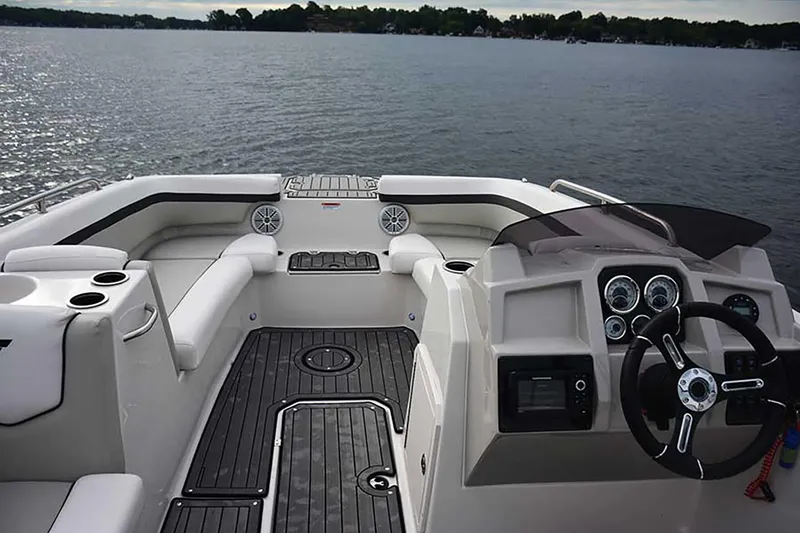 Slide: The Image of Manufacturer Provided Image: 2026 Starcraft SVX 211 OB boat interior with steering wheel and seating on a calm lake. - 15