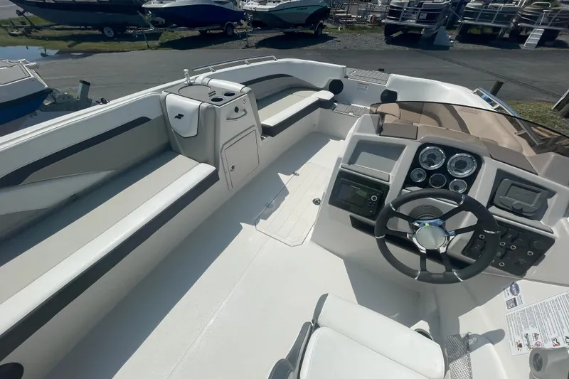 Slide: The Image of 2026 Starcraft SVX 211 OB boat interior with steering wheel and seating area. - 9