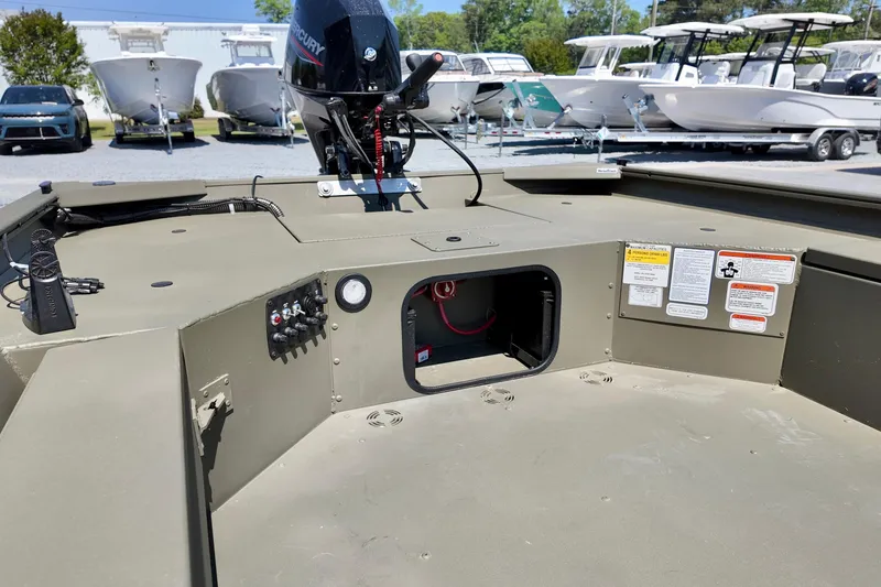 Slide: The Image of 2025 TRACKER BOATS 1654 MVX Sportsman interior with Mercury engine, control panel, and storage compartment. - 7