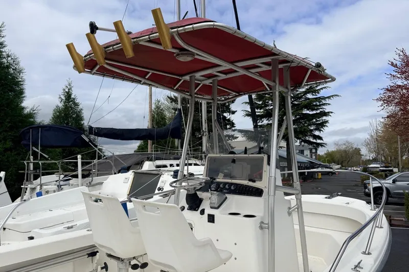 Slide: The Image of 1999 Boston Whaler Outrage 18 boat with red canopy and dual white seats. - 5