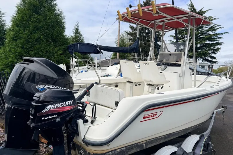 Slide: The Image of 1999 Boston Whaler Outrage 18 boat with Mercury outboard motor, parked on a trailer. - 8