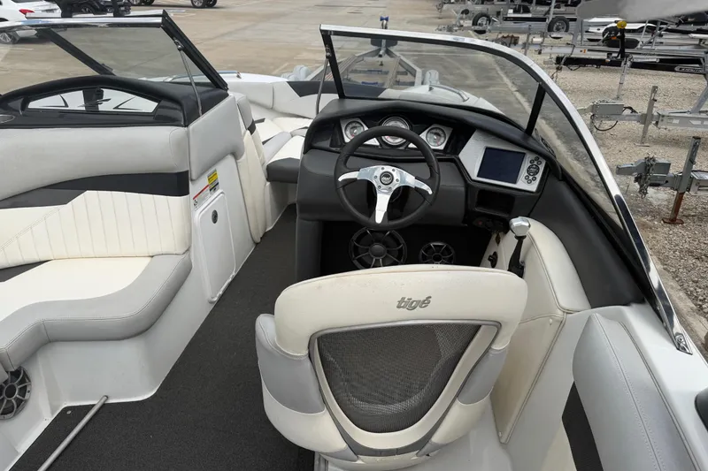 Slide: The Image of 2010 Tigé RZ2 boat interior with steering wheel, dashboard, and seating. - 11