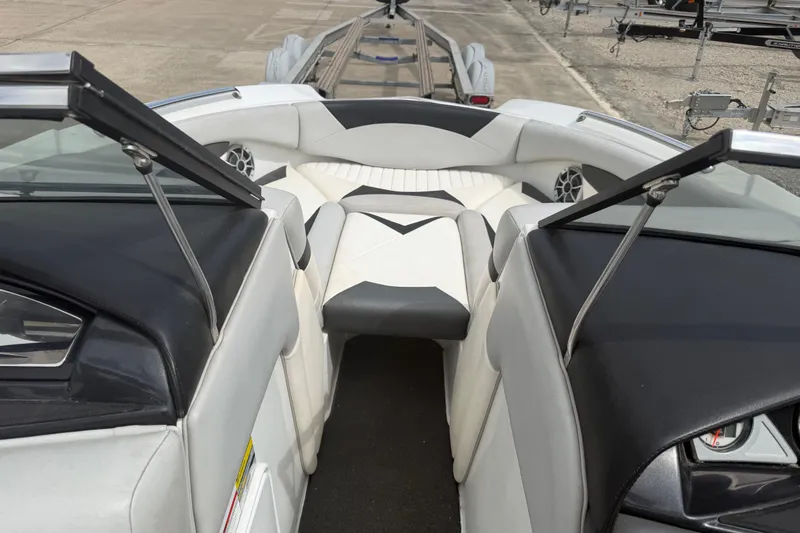 Slide: The Image of 2010 Tigé RZ2 boat interior with white and black seating, open windshield, and speakers. - 13