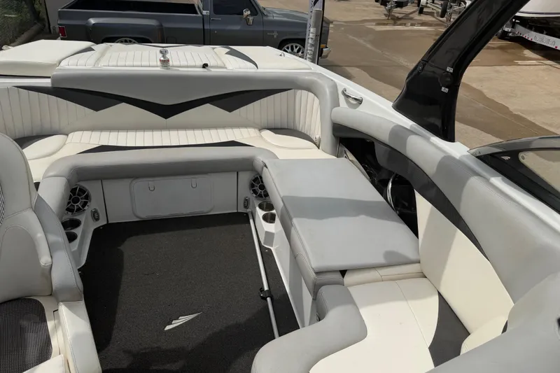 Slide: The Image of 2010 Tigé RZ2 boat interior with white and gray seating, cup holders, and speakers. - 16