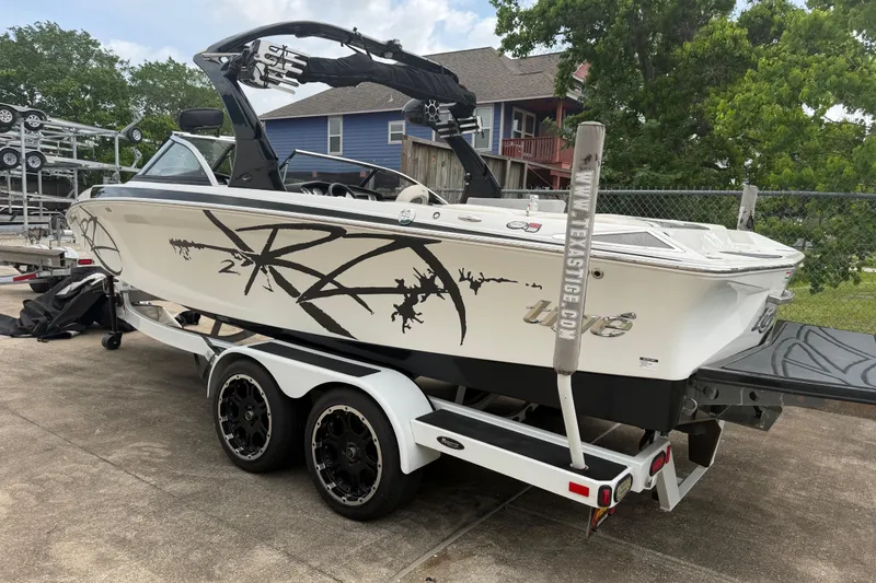 Slide: The Image of 2010 Tigé RZ2 boat on trailer, featuring sleek design and bold graphics. - 2