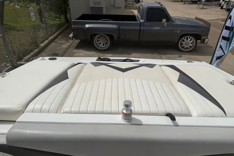 Slide: The Image of 2010 Tigé RZ2 boat interior with sleek upholstery, parked near a vintage truck. - 20