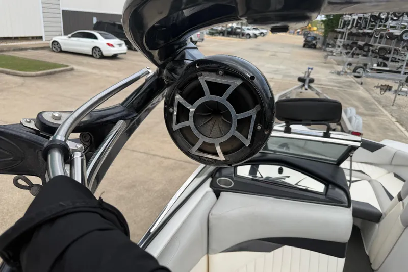 Slide: The Image of 2010 Tigé RZ2 boat interior with speaker and seating, parked in a lot. - 21