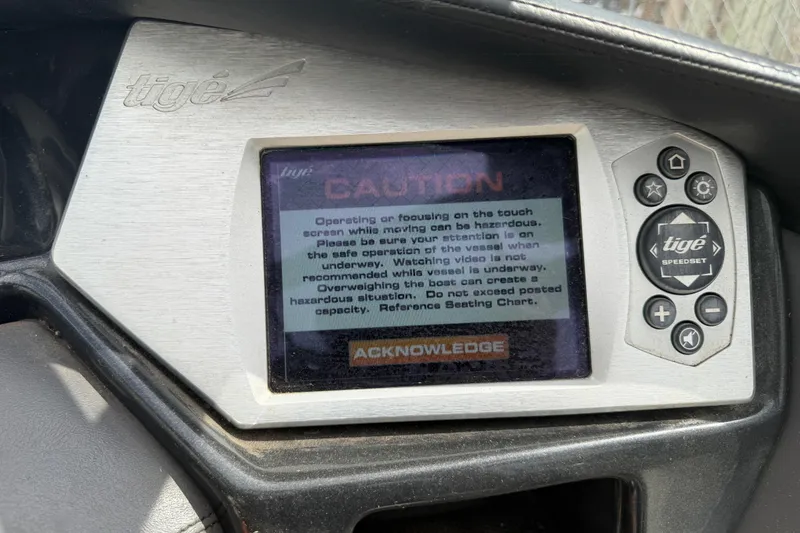 Slide: The Image of 2010 Tigé RZ2 dashboard with caution message on touchscreen display. - 31