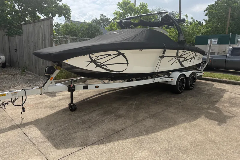 Slide: The Image of 2010 Tigé RZ2 boat on trailer, covered, parked outdoors. - 5