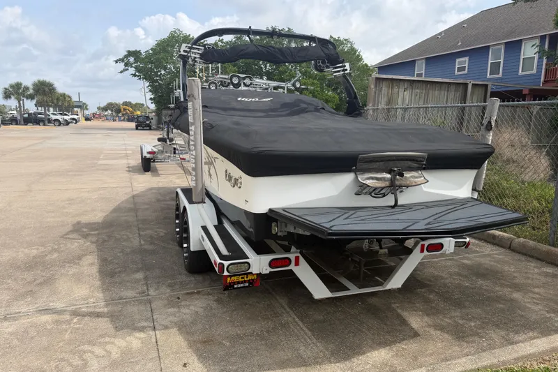 Slide: The Image of 2010 Tigé RZ2 boat on trailer, covered and parked in a residential area. - 6